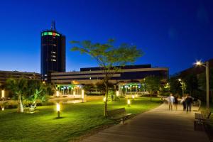 een groep mensen die 's nachts in een park wandelen bij UNAHOTELS T Hotel Cagliari in Cagliari