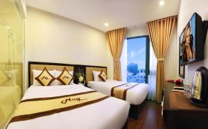 2 camas en una habitación de hotel con ventana grande en May Hotel, en Da Nang
