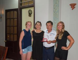 a group of three women and a man holding a plate at Royal Homestay in Hoi An