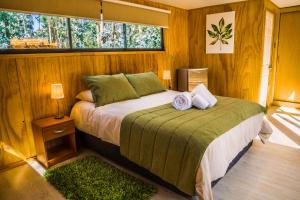 a bedroom with a bed and a window at El Bosque Lodge in Algarrobo