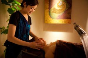 una mujer le está dando un masaje a un hombre en Hanagoyomi, en Sumoto