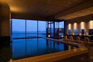a swimming pool in a hotel with a view of the ocean at Hanagoyomi in Sumoto