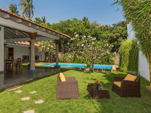 a yard with two chairs and a swimming pool at Kadal The Beach House in Puducherry