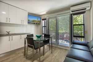 a kitchen and dining room with a table and a couch at Hamilton on Beaumont in Newcastle