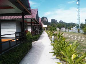 a walkway next to a train station with mountains in the background at PhiPhi Coralbay in Phi Phi Islands