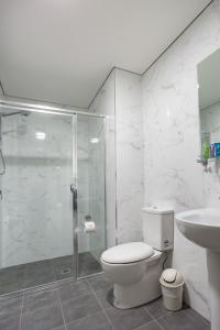 a bathroom with a shower and a toilet and a sink at Hamilton on Beaumont in Newcastle