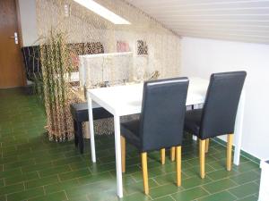 a white table with black chairs in a room at Ferienwohnung Schwäbische Alb in Justingen +6 photos