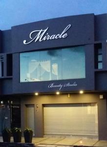 een groot gebouw met een bord dat wonderschoonheidskliniek leest bij Miracle Suite in Ipoh