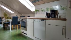 a kitchen with white appliances and a table with chairs at Ferienwohnung Schwäbische Alb in Justingen