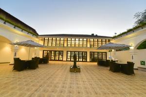 a large building with tables and umbrellas at Silver Sands Serenity in Candolim