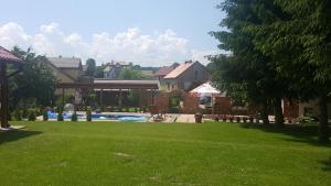 a green yard with a swimming pool and buildings at Cudowny Zakątek z Ogrodem i Basenem in Bukwica
