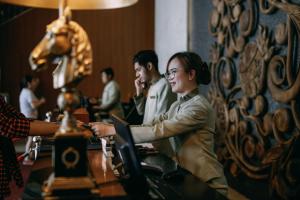 une femme assise à une table dans un bar dans l'établissement Hotel Granada Johor Bahru, à Johor Bahru