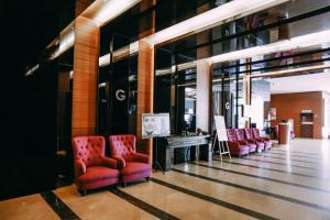 a lobby with red chairs and a counter in a store at Hotel Granada Johor Bahru in Johor Bahru