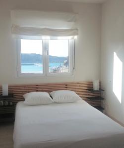 1 dormitorio con 1 cama blanca grande y ventana en Apartamento Bellavista, en Luarca