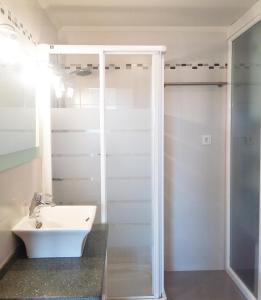 a white bathroom with a sink and a shower at Apartamento Bellavista in Luarca