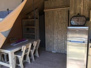een keuken met een tafel en een koelkast bij Glamping Lodge Estartit in L'Estartit