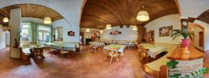 a restaurant with wooden ceilings and tables and chairs at Pension Rohrwald in Oberrohrbach