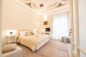 ein weißes Schlafzimmer mit einem Bett und einem Fenster in der Unterkunft Il Leone Blu in Catania