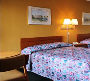 a hotel room with a bed and a table with a chair at Speedway Inn in Bristol +1 photo