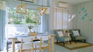 une salle à manger avec une table et des chaises et une fenêtre dans l'établissement Tascany Sea Beach Chaam-Huahin, à Cha Am