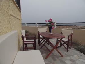 a wooden table with a vase of flowers on a balcony at Gianna's House in Stavros