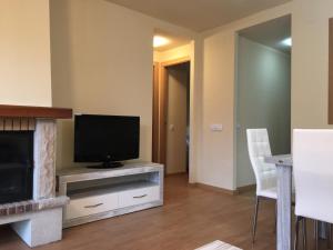 sala de estar con TV y chimenea en Apartament Vall d'Àger, en Àger