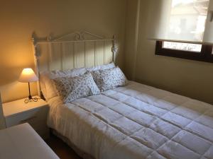 1 dormitorio con 1 cama blanca grande con lámpara en Apartament Vall d'Àger, en Àger