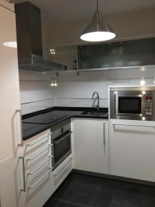 una cocina con fregadero y microondas en Apartament Vall d'Àger, en Àger 7 fotos más