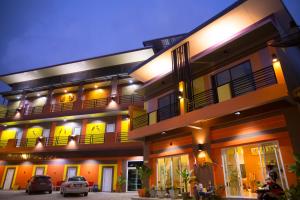 a building with cars parked in front of it at The Boat House in Ranong