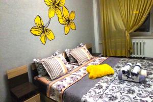 a bedroom with a bed with yellow butterflies on the wall at Apartments on Samal 1 in Almaty