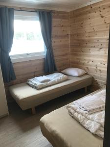 twee bedden in een kamer met een raam bij Rondaplassen in Kvam