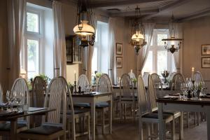 a dining room with tables and chairs and chandeliers at Skanörs Gästgifvaregård in Skanör med Falsterbo