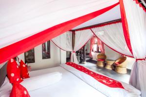 a bedroom with a red and white canopy bed at EcoTravel Cottages Bukit Lawang in Bukit Lawang
