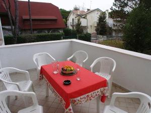 リニャーノ・サッビアドーロにあるLignano Pineta Villa mit Gartenの赤いテーブルクロスと白い椅子付きのテーブル