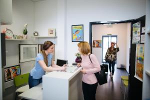 two women standing at a counter in a store at Hostel Villa Domus in Koper