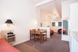 Habitación con mesa de comedor y dormitorio. en Mid City Motel, en Mount Gambier