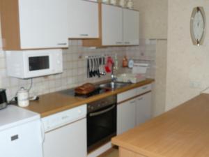 a kitchen with white cabinets and a sink at Ferienwohnung Rampitz in Rampitz