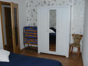 a bedroom with a closet with a mirror and a chair at Ferienwohnung Rampitz in Rampitz