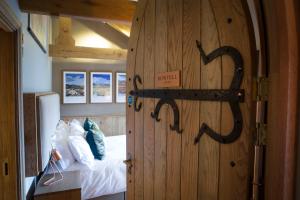 a bedroom with a wooden door with a bed in it at The Queen's Head Hotel in Troutbeck