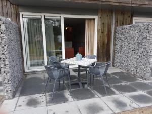 een tafel en stoelen op een patio bij De Kapershut in Hollum