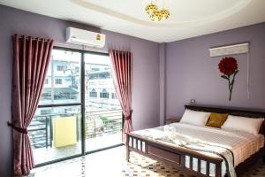 sypialnia z łóżkiem i dużym oknem w obiekcie The Boat House w mieście Ranong