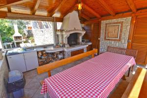 una cucina con tavolo a scacchi rosso e bianco e piano cottura di Apartments Creska 629 a Rabac