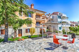 un tavolo e delle sedie davanti a un edificio di Apartments Creska 629 a Rabac