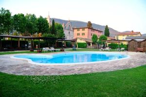 a swimming pool in the middle of a yard at Country House La Padronale Del Rivo in Rivotorto