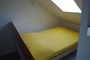 ein kleines Bett in einem kleinen Zimmer mit Fenster in der Unterkunft L'annexe in Étaples