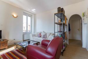 een woonkamer met een bank en een rode stoel bij T3 55m2 & Garage, proche Saône, et 5 min Vieux Lyon via Metro D in Lyon