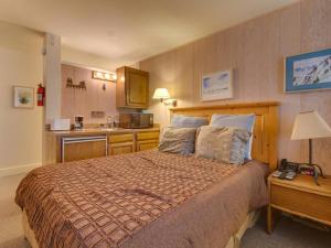 a bedroom with a large bed and a kitchen at Northstar Original Village Studio One in Truckee