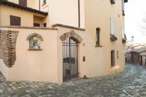 ein Gebäude mit einem Tor auf einer Kopfsteinpflasterstraße in der Unterkunft Vicolobellisei in Longiano