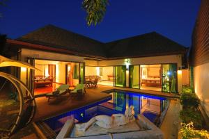una casa con piscina por la noche en Naiharn Beach Villa en Nai Harn Beach