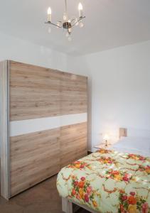 - une chambre avec un lit et une tête de lit en bois dans l'établissement ALBA Amazing Location Beach Apartments, à Biograd na Moru